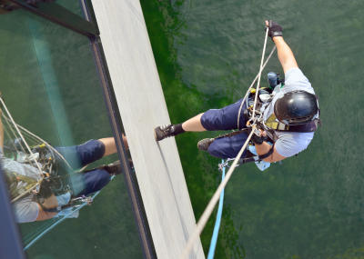 Glasreinigung am Seil in der Höhe, Gebäudereinigung mit Fassadenkletterer und Arbeit am Seil